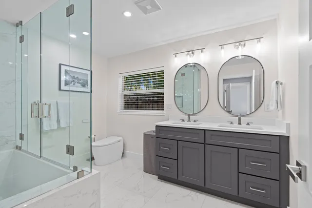 a bathroom with a granite countertop sink mirror toilet and bathtub