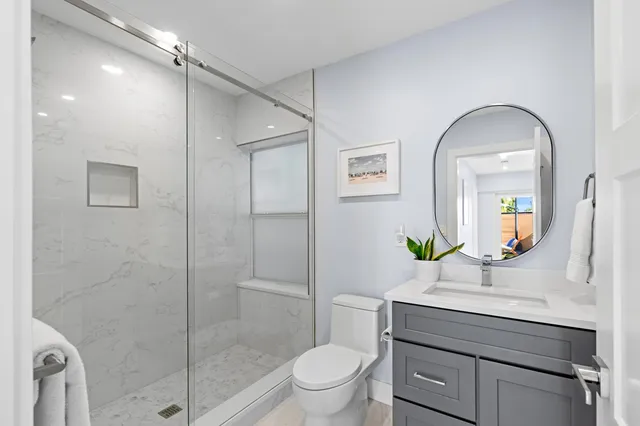 a bathroom with a toilet a sink and glass door