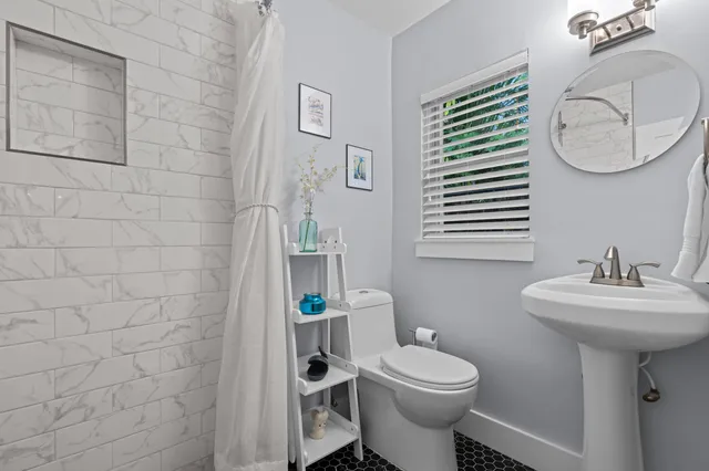 a bathroom with a toilet sink and mirror
