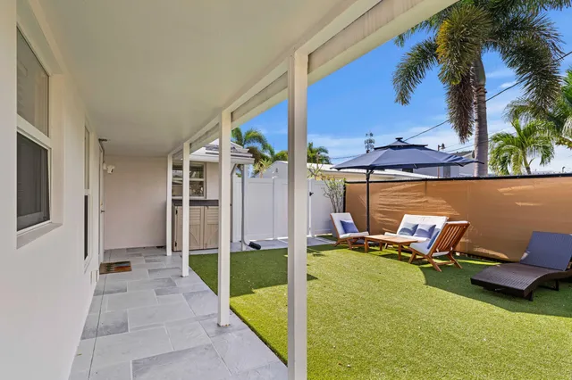 a view of a backyard with table and chairs under an umbrella