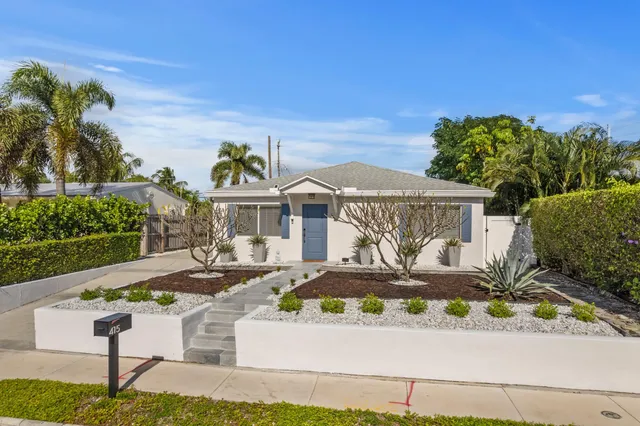a front view of a house with a garden