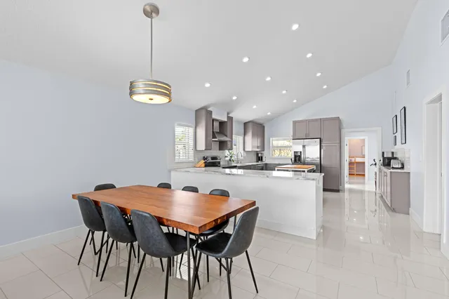 a dining room with stainless steel appliances kitchen island a table and chairs