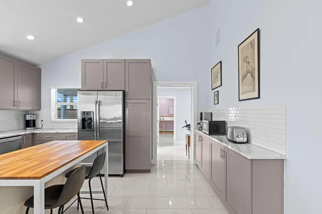 a kitchen with stainless steel appliances kitchen island granite countertop a refrigerator and a stove top oven