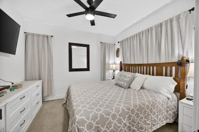 a spacious bedroom with a bed and a flat screen tv