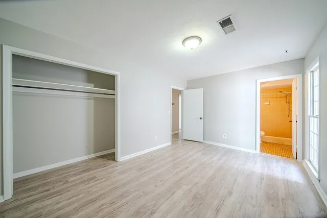 an empty room with wooden floor and closet