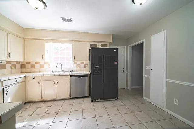 a kitchen with stainless steel appliances granite countertop a refrigerator and a sink