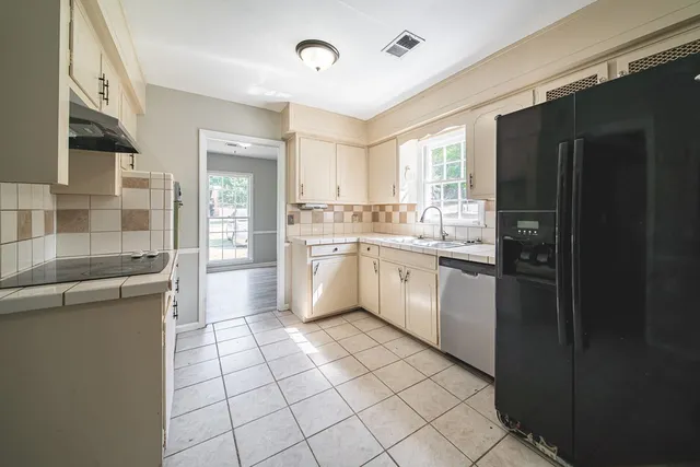 a kitchen with a sink a stove cabinets and refrigerator