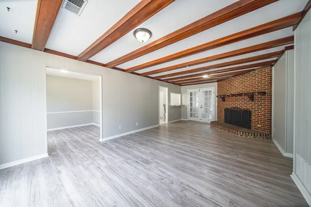 a view of empty room with wooden floor and fireplace