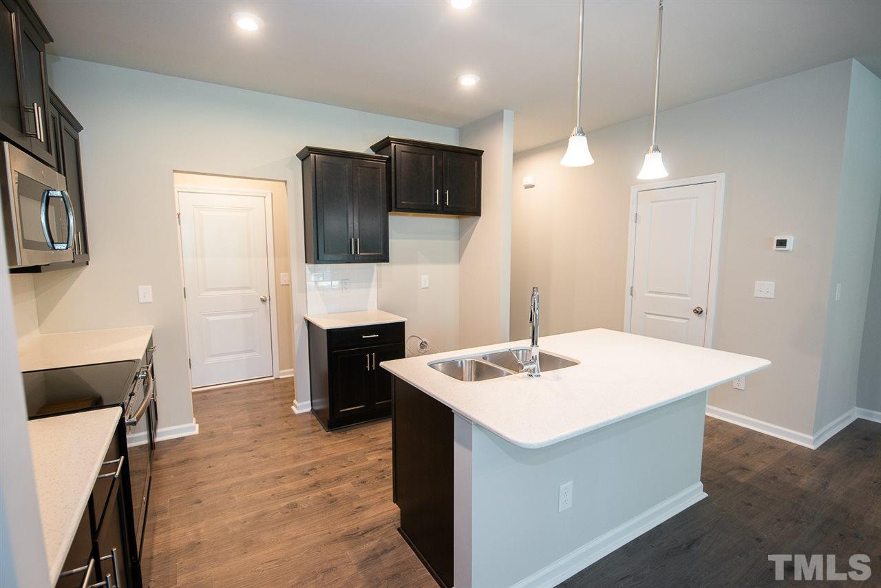 3645 Water Mist Lane, Unit 9 Raleigh, NC 27604 - Photo 4 of 26 a kitchen that has a sink a stove and chairs