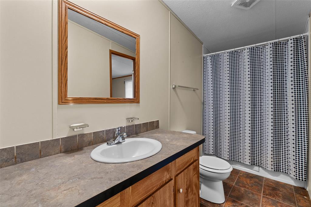 334 Destiny Lane Keatchie, LA 71046 - Photo 22 of 29 Full bath with vanity, shower / tub combo with curtain, and a textured ceiling