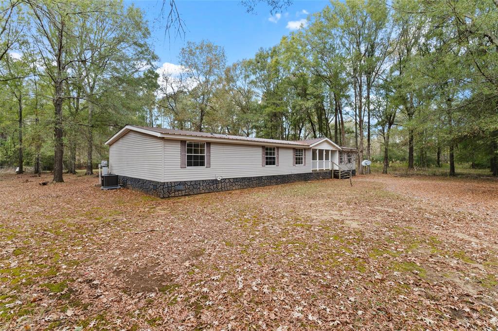 334 Destiny Lane Keatchie, LA 71046 - Photo 4 of 29 View of front facade with crawl space, a sunroom, and view of wooded area