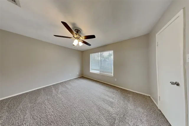 a view of a livingroom with a ceiling fan and window