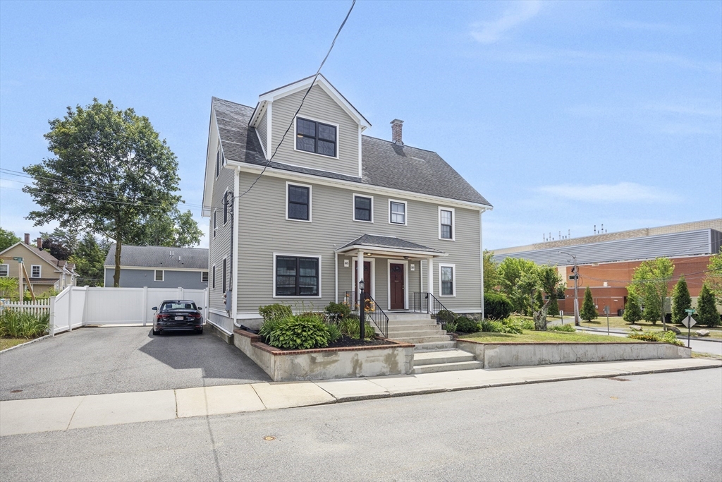 48 Spruce Street, Unit 1 Winchester, MA 01890 - Photo 23 of 29 a front view of a house with a yard and potted plants