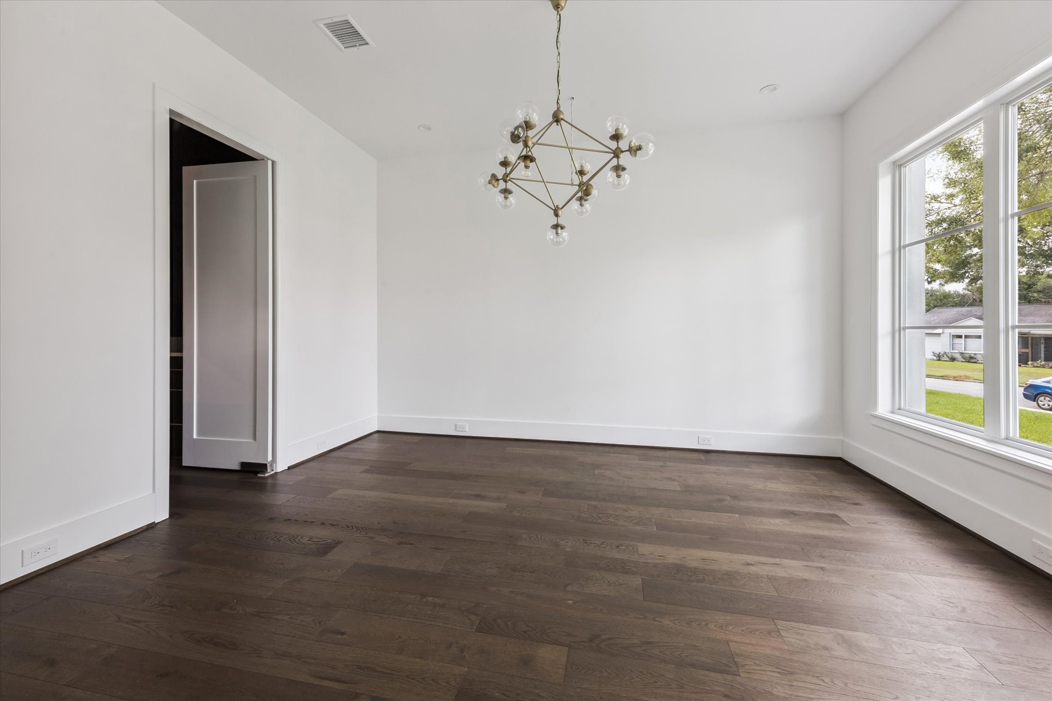 3011 Deal Street Houston, TX 77025 - Photo 11 of 45 an empty room with wooden floor chandelier and windows