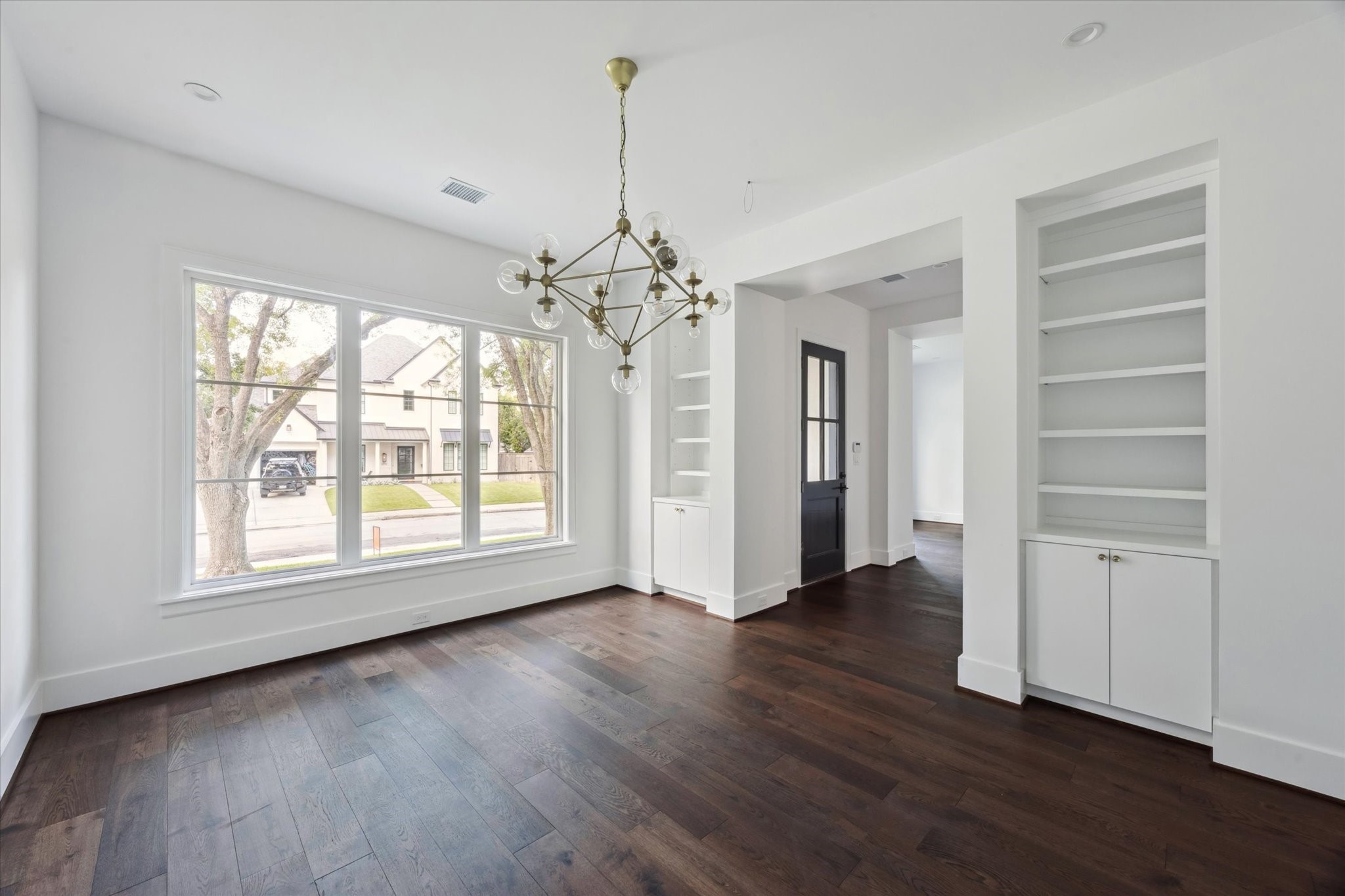 3011 Deal Street Houston, TX 77025 - Photo 10 of 45 an empty room with wooden floor chandelier and windows