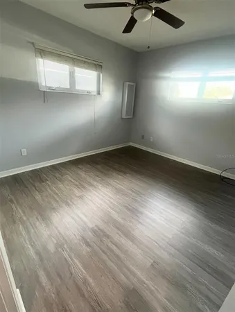 an empty room with windows and fan