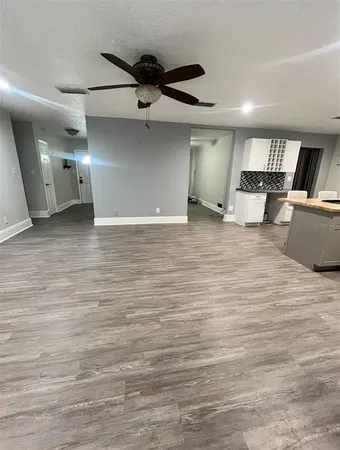 a view of a livingroom with a ceiling fan and wooden floor