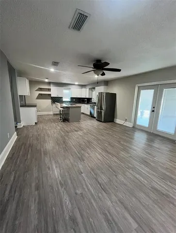 a living room with furniture and a wooden floor