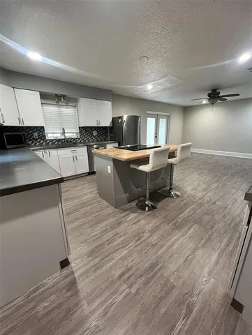 a living room with stainless steel appliances kitchen island granite countertop wooden floor and view living room