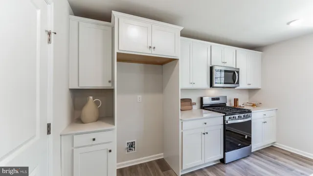 a kitchen with white cabinets and appliances