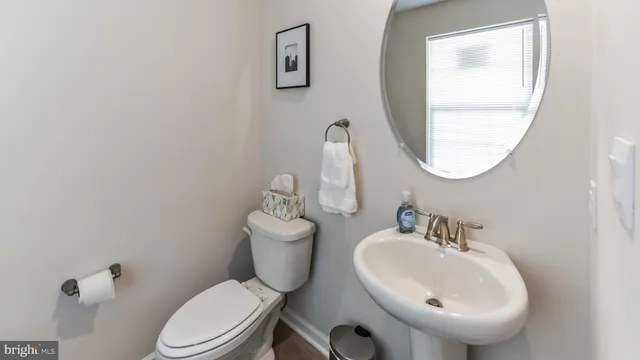 a bathroom with a toilet a sink and mirror