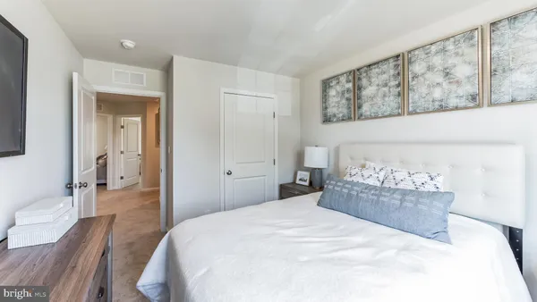 a bedroom with a large bed and wooden floor
