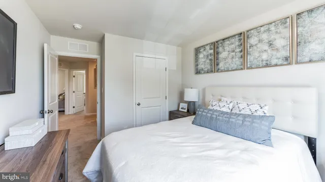 a bedroom with a large bed and wooden floor