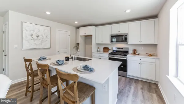 a kitchen with stainless steel appliances a white table and chairs