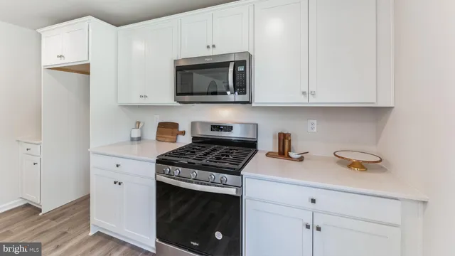 a kitchen with white cabinets and appliances