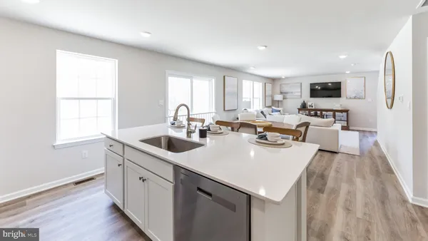 a kitchen with a sink dishwasher a stove and a refrigerator with wooden floor