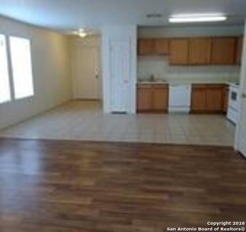 a kitchen with stainless steel appliances wooden cabinets and a wooden floor