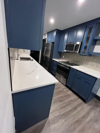 a kitchen with stainless steel appliances wooden cabinets a sink dishwasher a stove and a refrigerator