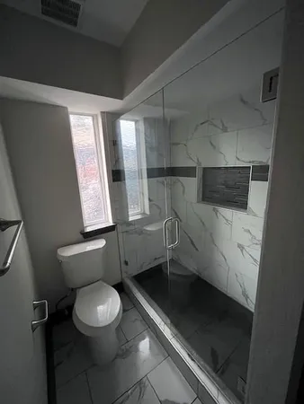 a bathroom with a toilet a sink and a window