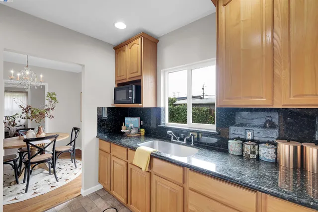 a kitchen with stainless steel appliances granite countertop sink stove and white cabinets with wooden floor