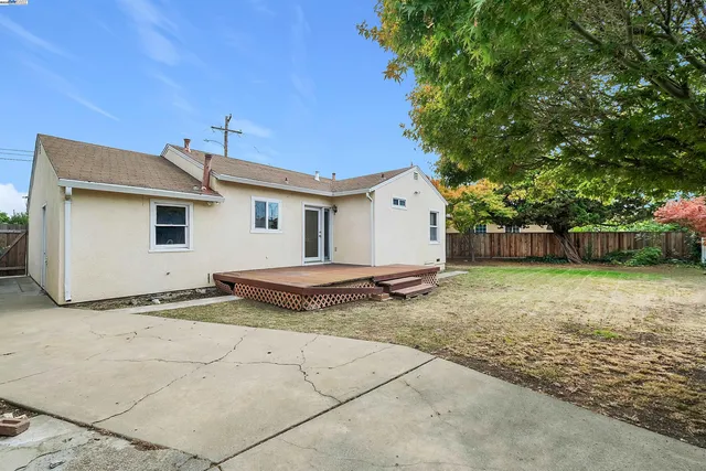 a view of a house with backyard and a tree