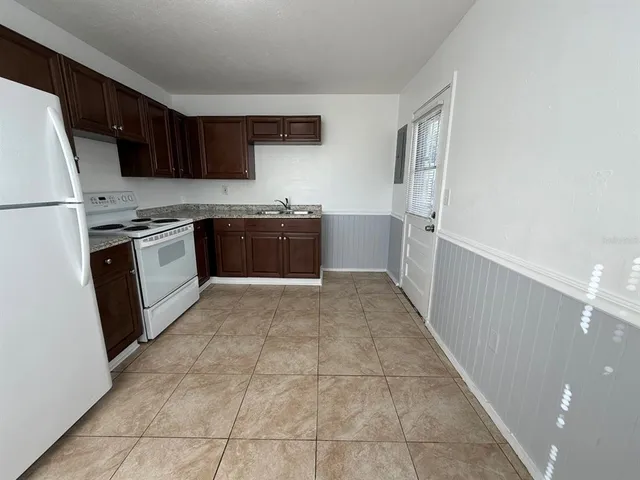 a kitchen with stainless steel appliances granite countertop a refrigerator and a stove