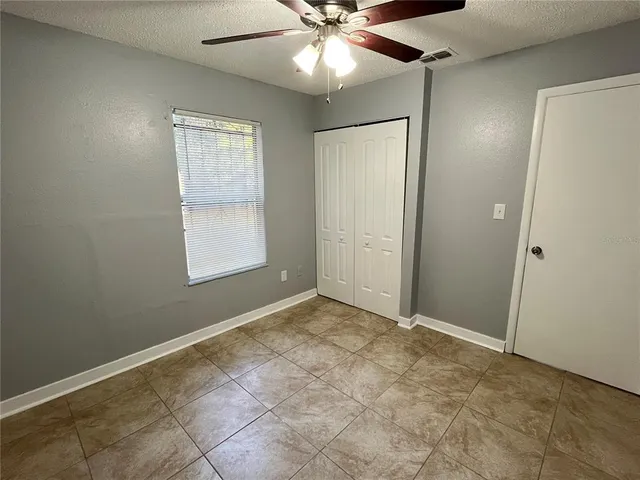 an empty room with fan and windows