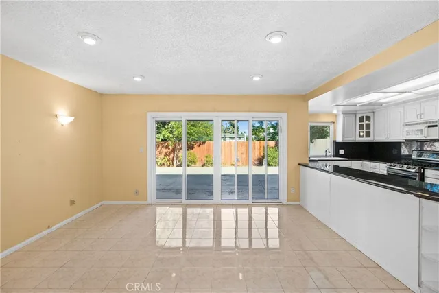 a view of a kitchen with a sink and dishwasher a stove top oven with wooden floor