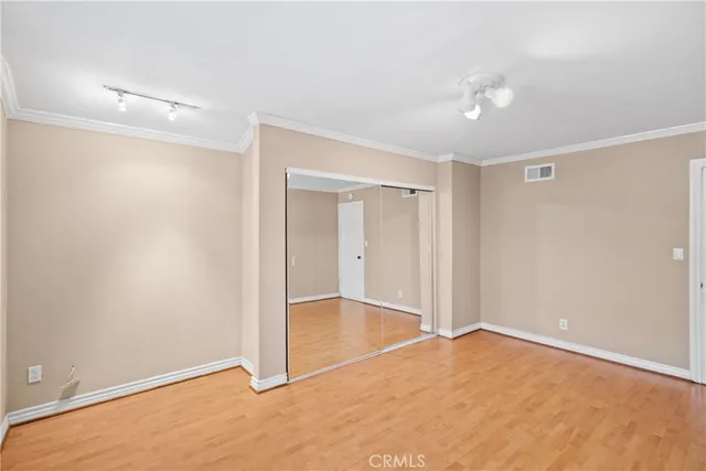 an empty room with closet and a chandelier fan