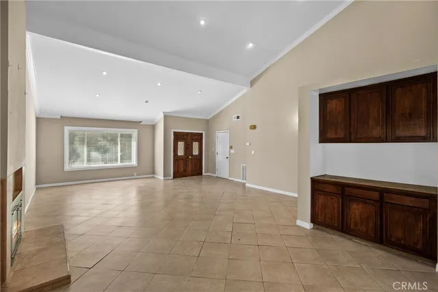 a view of an empty room with cabinet and a window