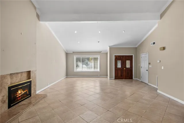 a view of an empty room with a fireplace and a window