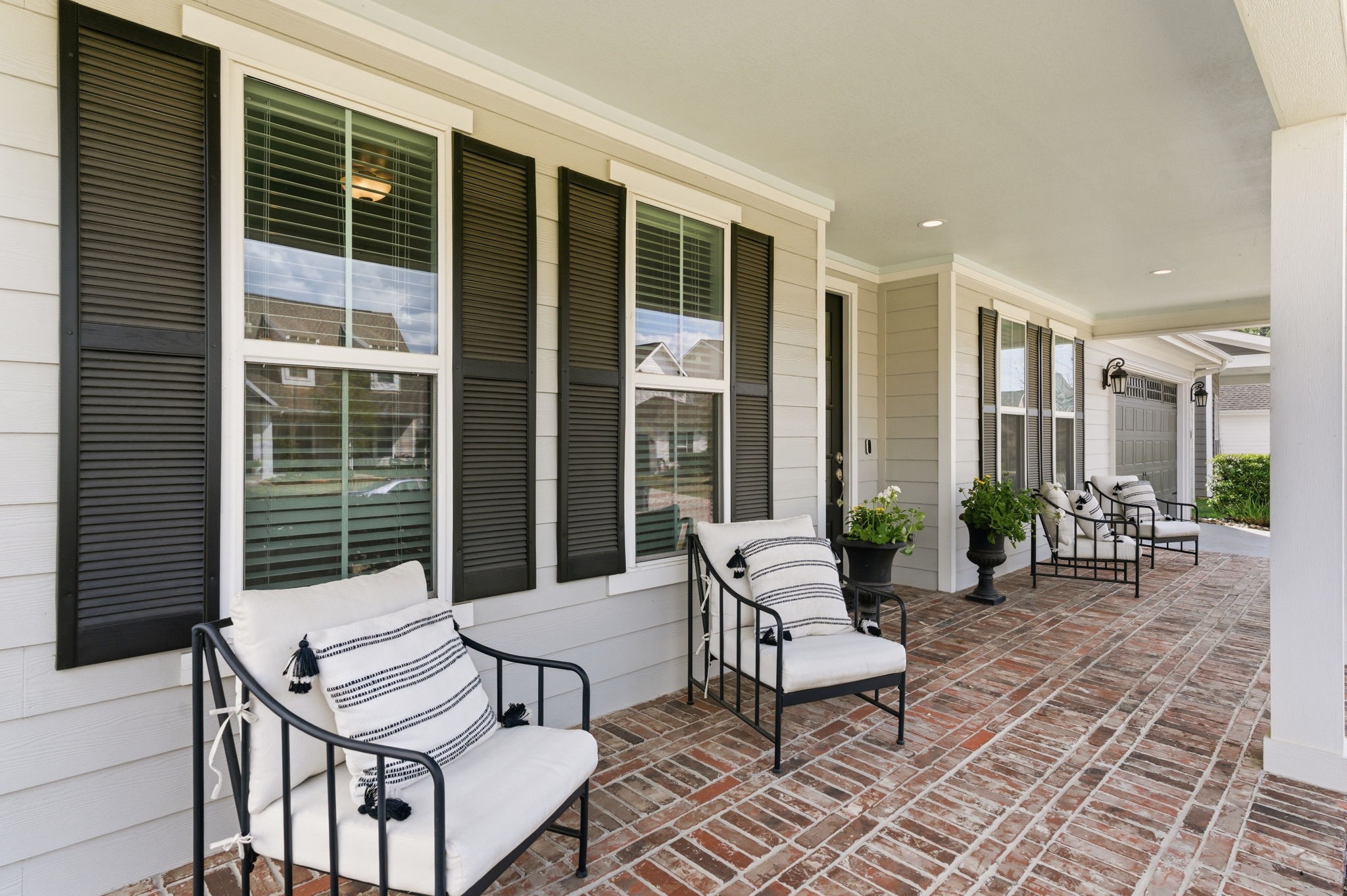 2208 Salt Grass Trail Conroe, TX 77384 - Photo 33 of 34 The brick paves on the patio and shuttered windows flank the home beautifully and in such a welcoming fashion. Give you a pause to breathe as you enter this completely functional floorplan.