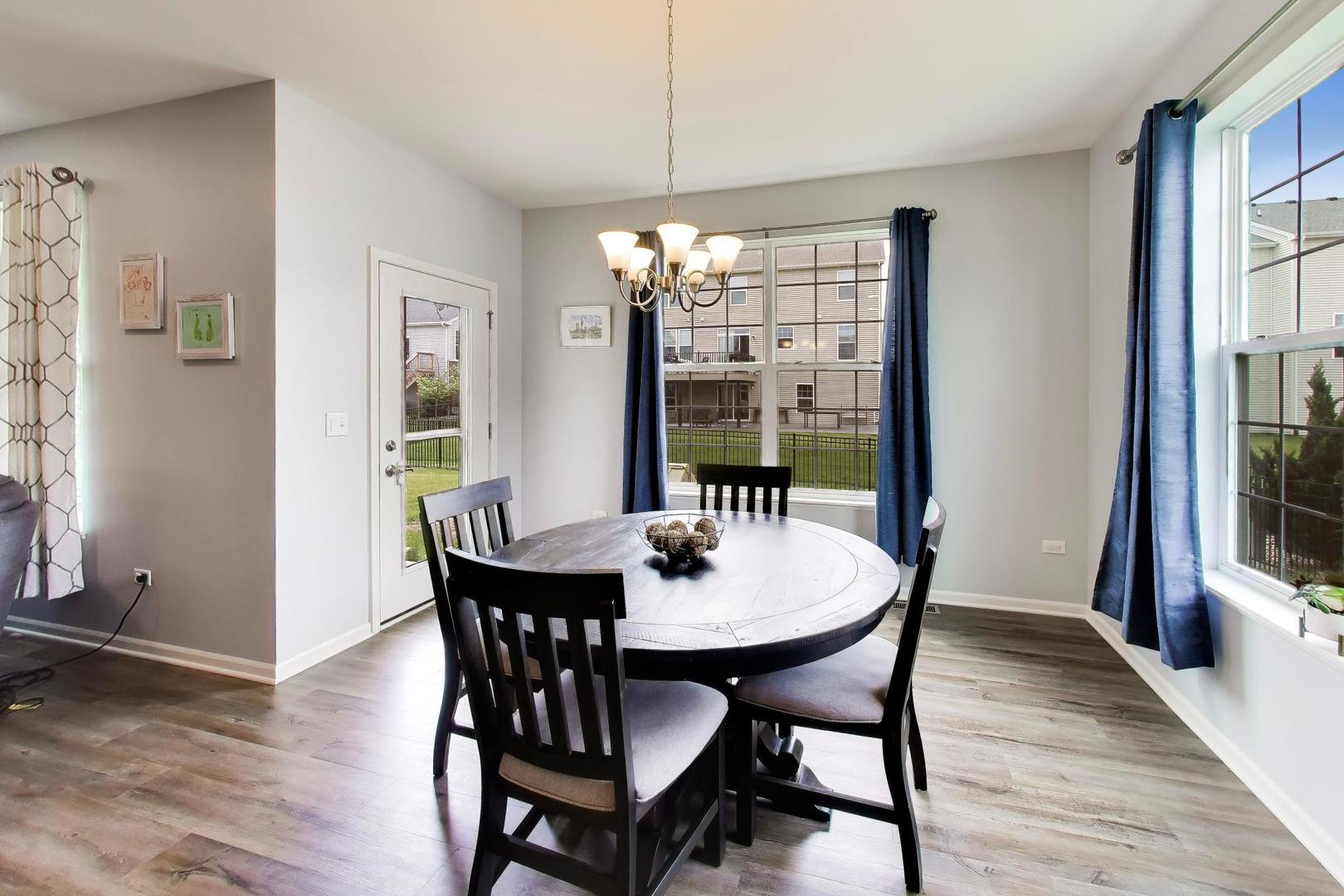 14831 Whitney Street Manhattan, IL 60442 - Photo 10 of 37 a dining room with furniture a chandelier and wooden floor