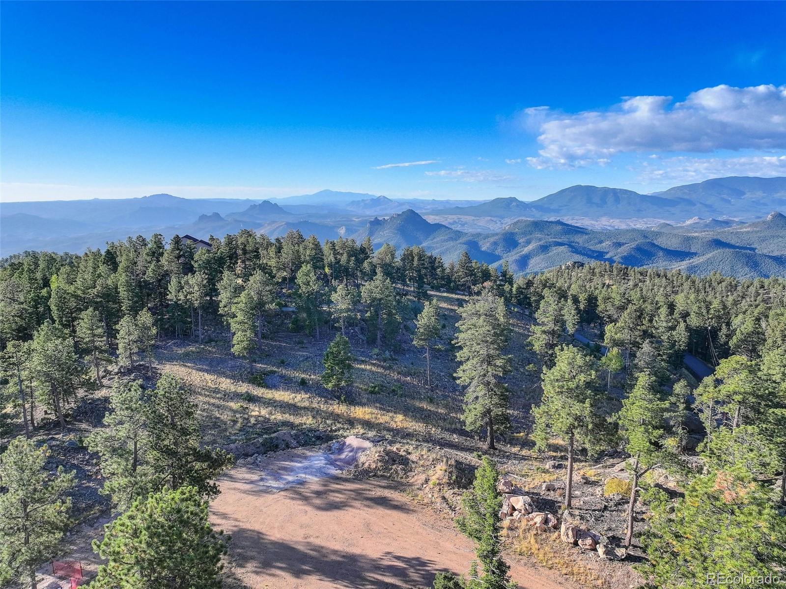 23047 Big Game Trail Conifer, CO 80433 - Photo 5 of 41 a view of a forest with mountains in the background