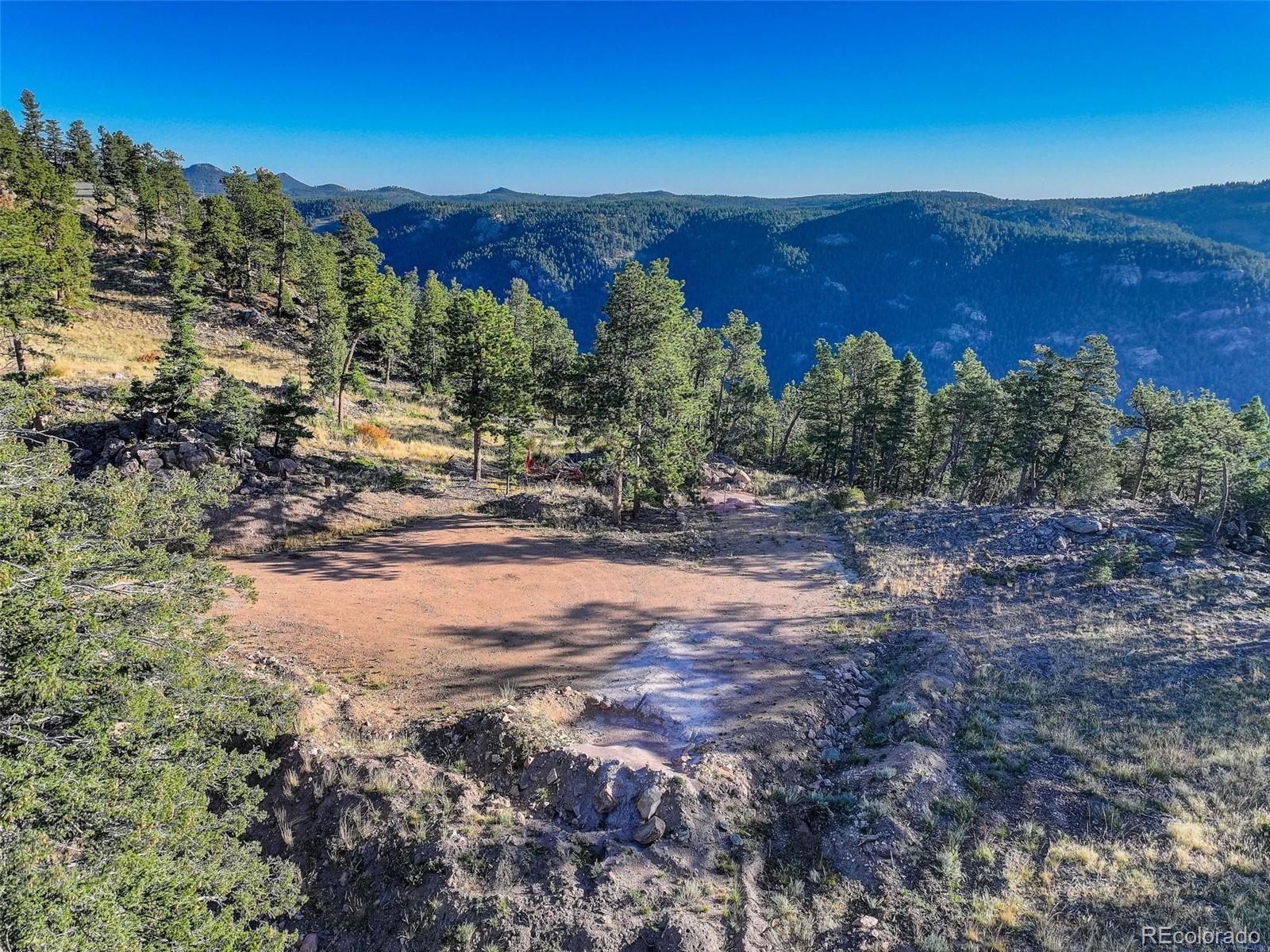 23047 Big Game Trail Conifer, CO 80433 - Photo 10 of 41 a view of a forest with mountains in the background