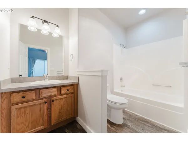 a bathroom with a granite countertop sink a toilet and a mirror