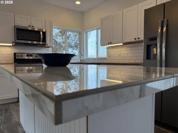 a kitchen with stainless steel appliances granite countertop a sink stove and microwave