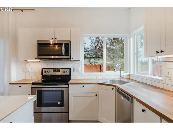 a kitchen with a stove a sink and a microwave