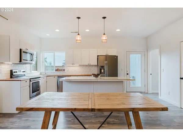 a open kitchen with kitchen island a sink stainless steel appliances and cabinets