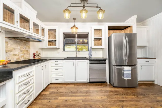 a kitchen with stainless steel appliances a refrigerator and a stove top oven